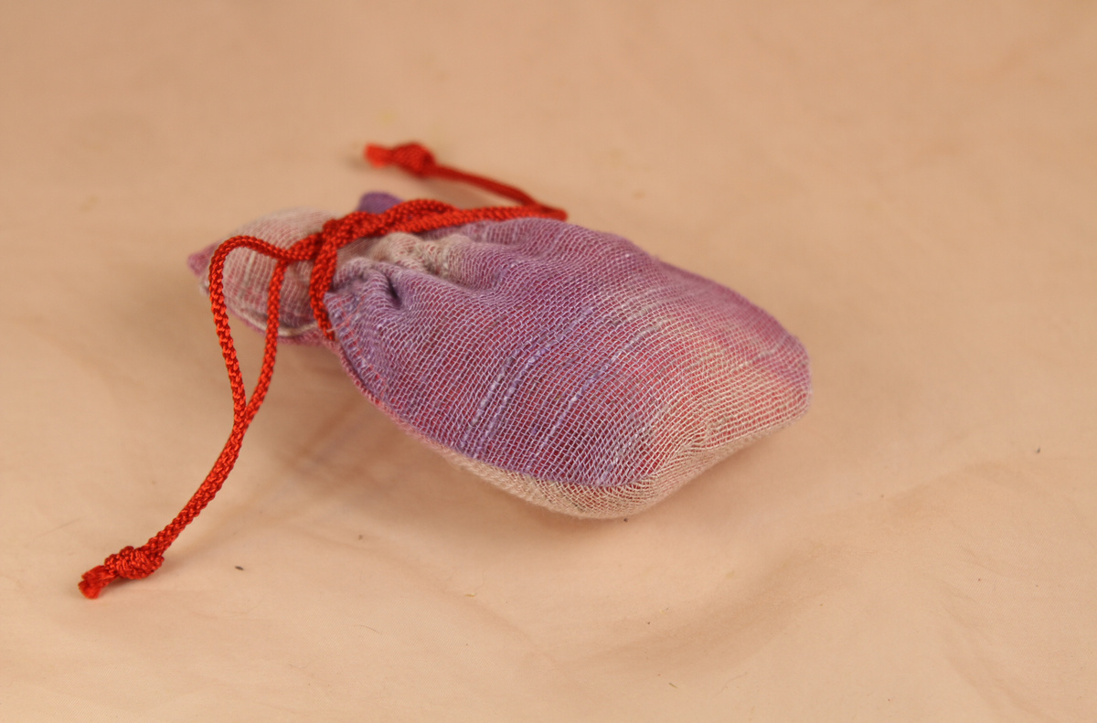 貝合わせを入れる専用の袋です。素材は麻で染色の清家文香さんが染めて、手作りした物です。