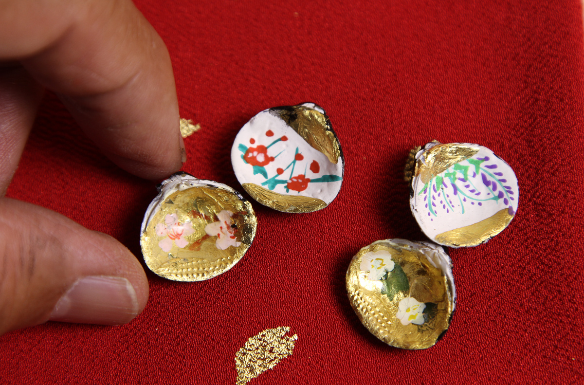 2組の貝合わせです。それぞれの大きさが1，5〜2ｃｍ程度の小さな貝合わせに金箔を貼り、四季の花を手描き彩色しています。